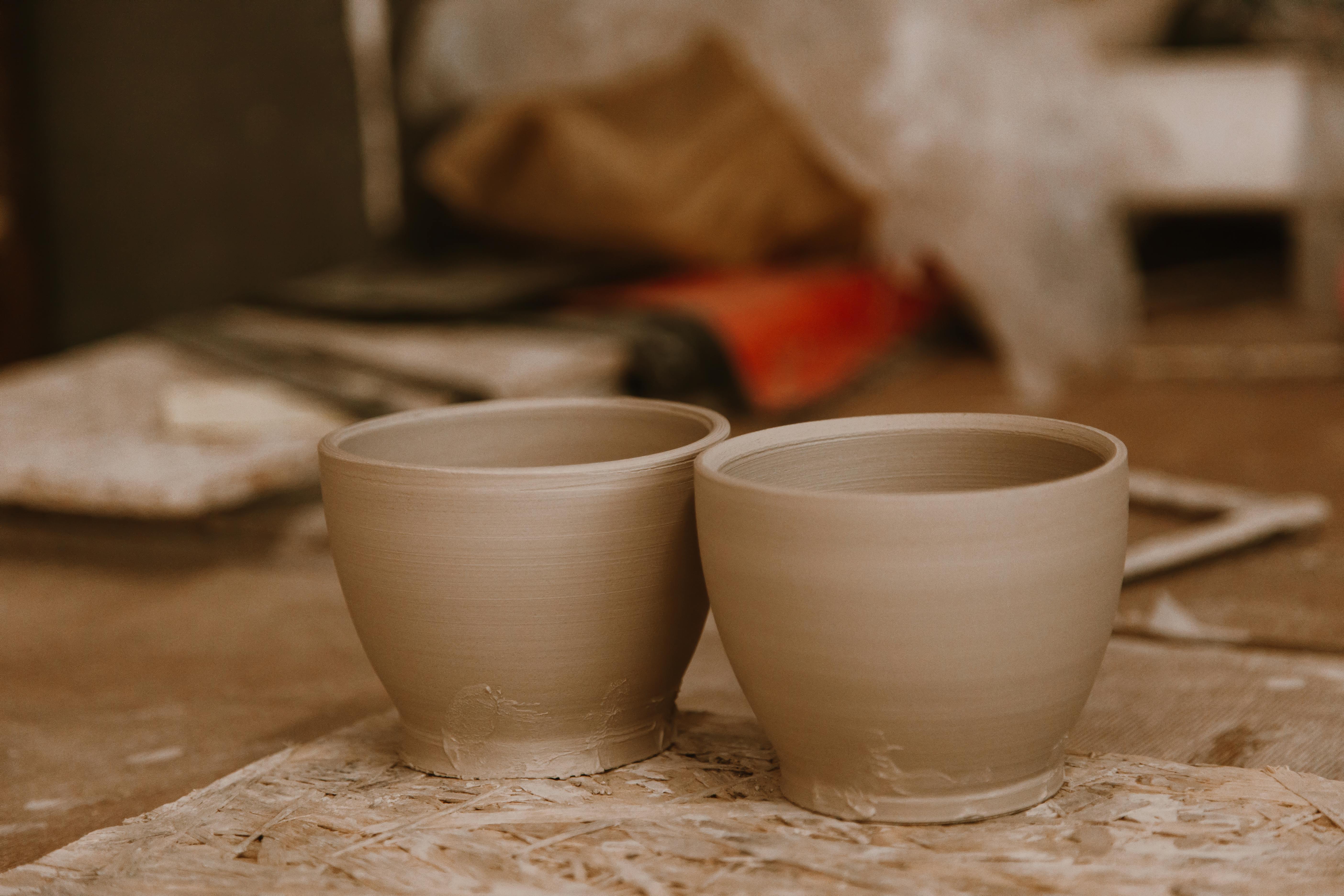 handcrafted ceramic cups on a pottery work table